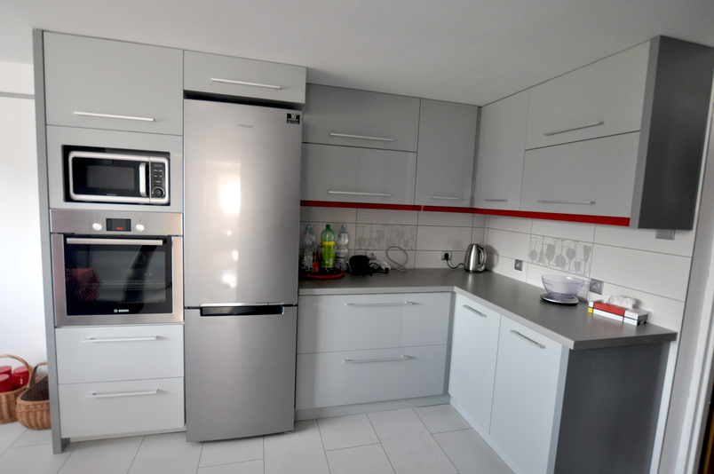 Klasyczna kuchnia narożna na wymiar w jasnej kolorystyce z elegancką zabudową AGD i praktycznym układem szafek.